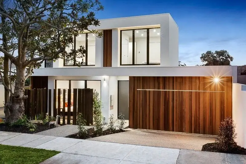Two-storey white home with timber garage door and landscaped entry