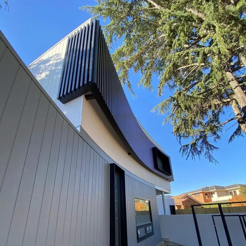 Detail of sculpted rooflines and vertical cladding on a home exterior