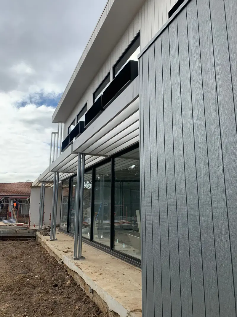 Vertical exterior cladding being installed on a home