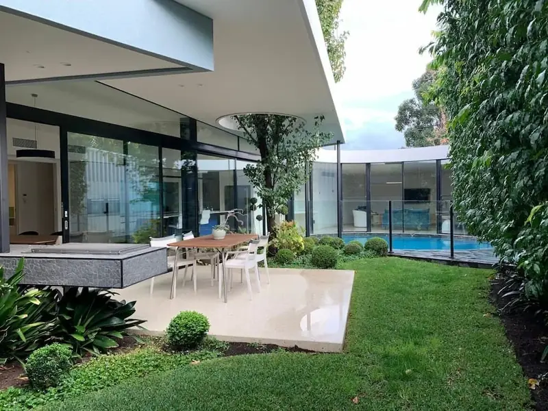 Covered terrace overlooking a landscaped garden and lawn